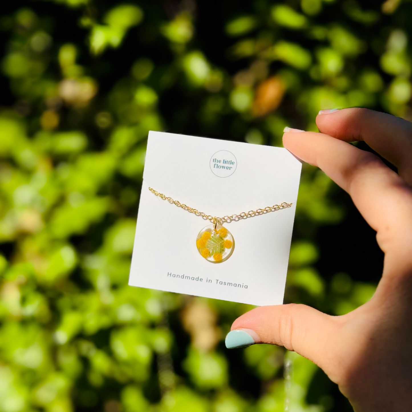 Native Wattle Necklace with real Australian wattle flowers preserved in clear resin on a gold-plated chain.