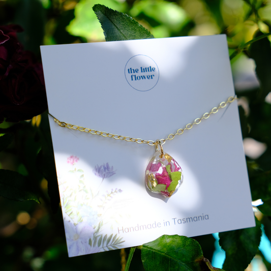 Red Rose Petal Necklace with a teardrop-shaped pendant on a card labeled 'the little flower' with a floral design.